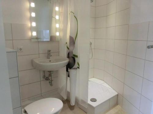 a white bathroom with a toilet and a sink at Landquartier in Schwesing