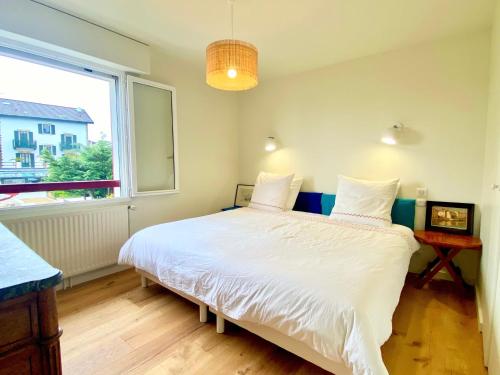 a bedroom with a large white bed and a window at Guethary superbe appartement centre proche plage in Guéthary