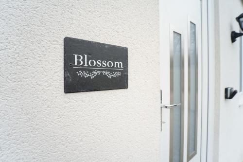 a sign that reads blossom on a wall next to a door at Beach Condos in Weston-super-Mare