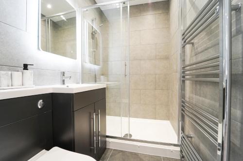 a bathroom with a shower and a toilet and a sink at Beach Condos in Weston-super-Mare