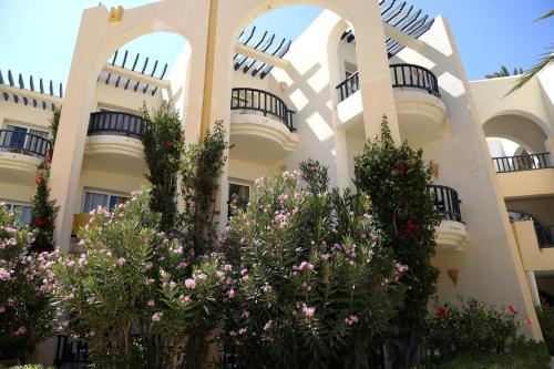ein Apartmenthaus mit Blumen davor in der Unterkunft Eden Star Resort in Zarzis