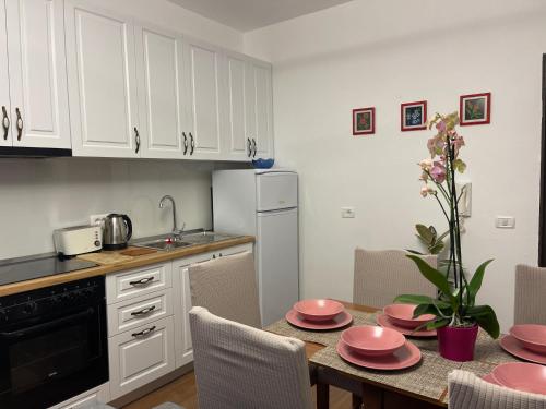 a kitchen with a table with pink dishes on it at Arteg Apartments - Premium in Durrës