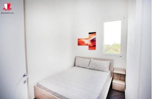 niewielka sypialnia z łóżkiem i oknem w obiekcie Chianurré w mieście Partinico
