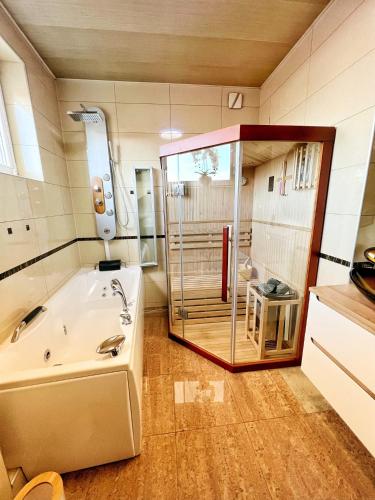 a bathroom with a tub and a glass shower at Apartament Premium Skawina in Skawina