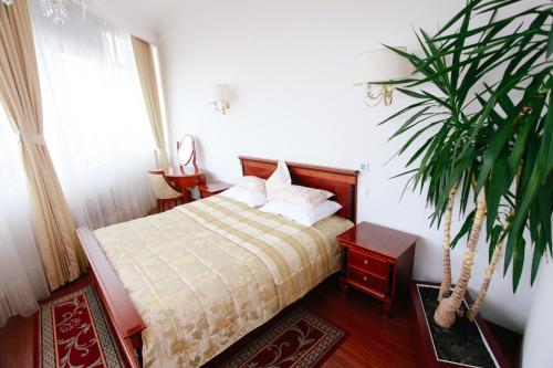 a bedroom with a bed and a potted plant at Apart-hotel Integra in Banja Luka