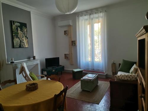 ein Wohnzimmer mit einem Tisch und einem Sofa in der Unterkunft Appartement cozy au cœur du village in Roquebrune-sur-Argens