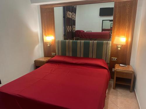 1 dormitorio con cama roja y espejo en Rm guest house 2, en Roma