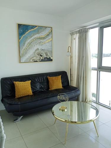 a living room with a black couch and a glass table at Ecusuites Riverfront One Vista al Río Jacuzzi Hidro in Guayaquil