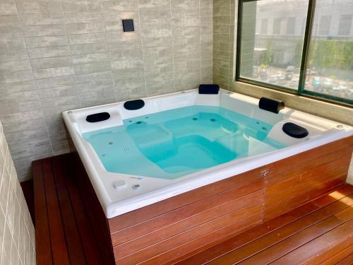 a jacuzzi tub in a room with a window at ARPOAR - Manaíra by PenareiaTurBr in João Pessoa