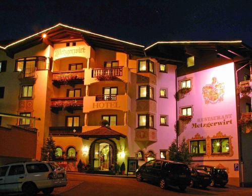 a hotel with cars parked in front of it at night at Hotel Metzgerwirt in Kirchberg in Tirol