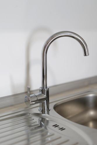 eine Küchenspüle mit einem verchromten Wasserhahn in der Unterkunft Apartments Villa Bernarda in Šilo