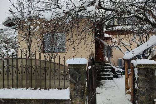 une maison avec une clôture dans la neige dans l'établissement Casa Roza, à Breaza de Sus