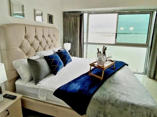 a bedroom with a large bed with a large window at Ecusuites Riverfront One Vista al Río Jacuzzi Hidro in Guayaquil