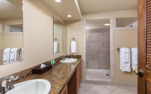 a bathroom with two sinks and a shower at Kona Coast Resort in Kailua-Kona