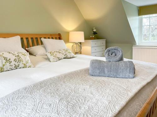una camera da letto con un letto e un asciugamano sopra di The Bothy a Lymington