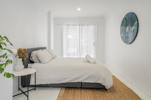 une chambre blanche avec un lit et une table dans l'établissement Lennox Beach Oasis 3 Bedrooms in town, à Lennox Head