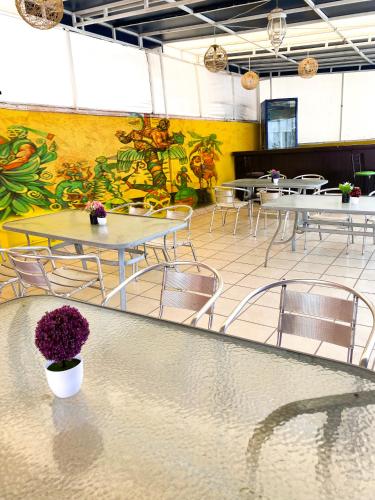 a dining room with tables and chairs and a mural at Hotel Amigo Suites in Mexico City
