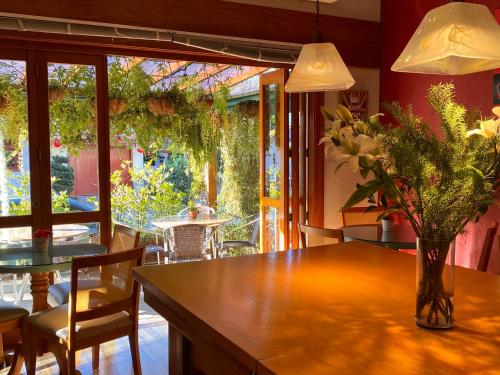 Hotel Britanico Express في غرامادو: غرفة طعام مع طاولة مع إناء من الزهور عليها