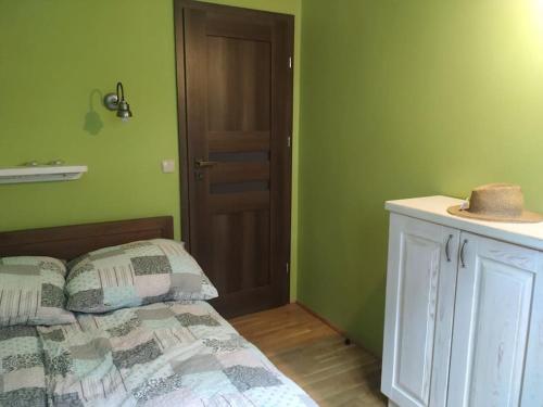 sypialnia z zielonymi ścianami i łóżkiem z kapeluszem w obiekcie Klimatyczny apartament nad jeziorem w Łagowie