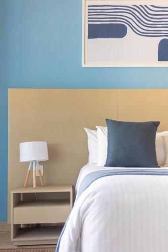 a bedroom with a bed with a blue and yellow wall at Ixchel Beach Hotel in Isla Mujeres