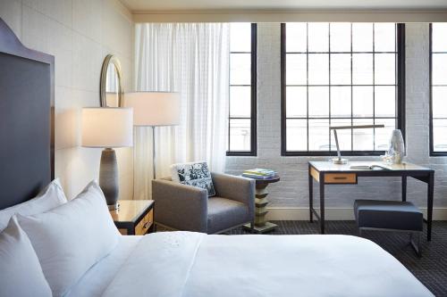 a hotel room with a bed and a chair and a desk at Renaissance New Orleans Arts Warehouse District Hotel in New Orleans