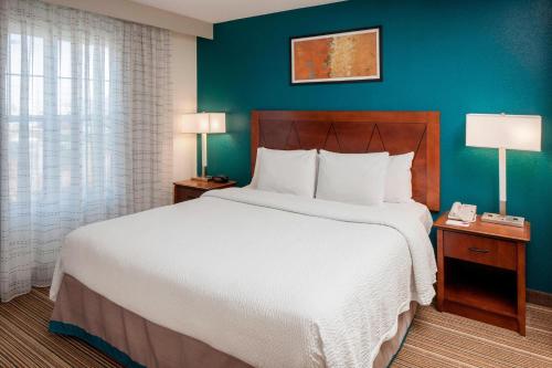 - une chambre avec un grand lit et un mur bleu dans l'établissement Residence Inn Boston Norwood, à Norwood