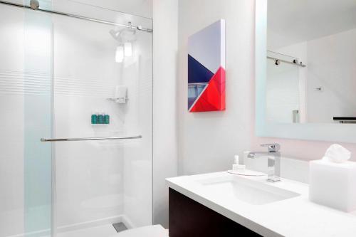 y baño blanco con lavabo y ducha. en TownePlace Suites by Marriott Columbus Easton Area en Columbus
