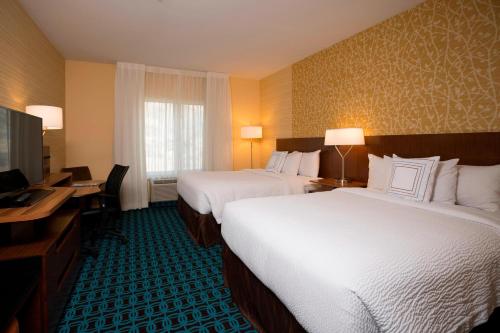 a hotel room with two beds and a desk and a television at Fairfield Inn & Suites by Marriott Durango in Durango