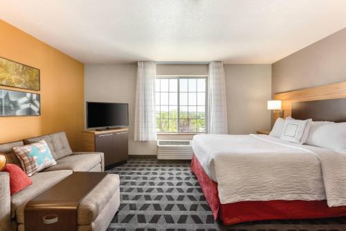 レイクウッドにあるTownePlace Suites by Marriott Denver West Federal Centerのベッドとソファ付きのホテルルーム
