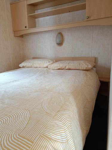 een bed met twee kussens erop bij Rhosfeillion Static Caravan in Llangefni