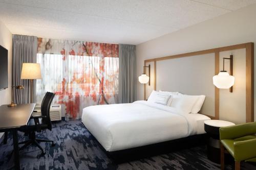 a hotel room with a large white bed and a desk at Fairfield Inn & Suites by Marriott Denver Southwest/Lakewood in Lakewood