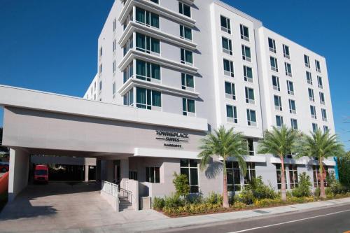 a white building with palm trees in front of it at TownePlace Suites by Marriott Miami Airport in Miami