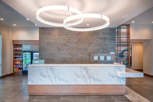 a lobby with a marble counter and two large lights at TownePlace Suites by Marriott Miami Airport in Miami