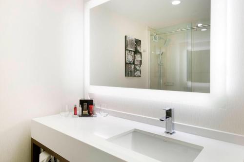 a white bathroom with a sink and a mirror at Greensboro-High Point Marriott Airport in Greensboro