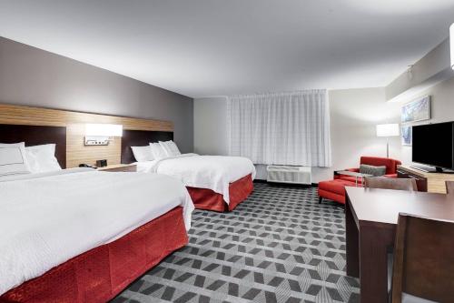 TownePlace Suites by Marriott Austin Parmer/Tech Ridge في أوستن: غرفة فندقية بسريرين وتلفزيون بشاشة مسطحة
