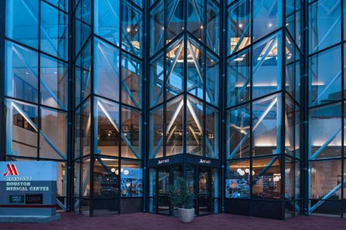 a glass building with a potted plant in front of it at Houston Marriott Medical Center/Museum District in Houston