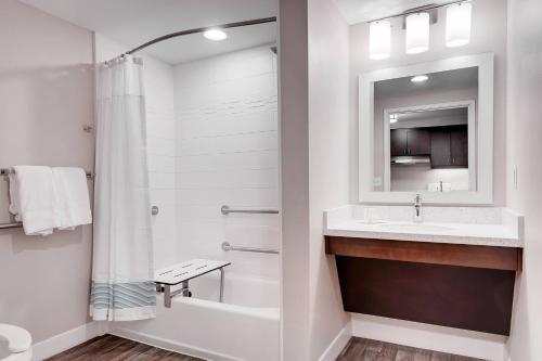 a white bathroom with a sink and a shower at TownePlace Suites by Marriott Austin Parmer/Tech Ridge in Austin