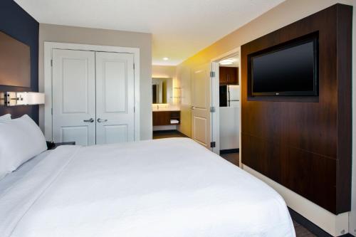 a bedroom with a large bed and a flat screen tv at Residence Inn by Marriott Ann Arbor North in Ann Arbor