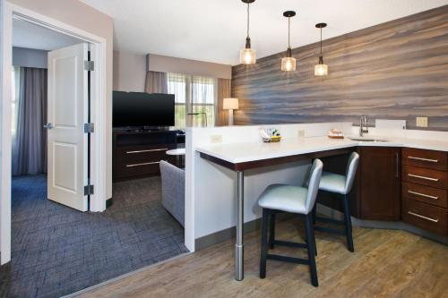 a kitchen with a counter and a table and chairs at Residence Inn by Marriott Ann Arbor North in Ann Arbor