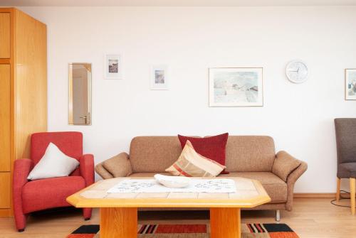 ein Wohnzimmer mit einem Sofa und einem Couchtisch in der Unterkunft Haus Hanseatic, Wohnung 302 in Duhnen