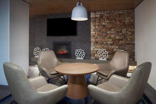 a meeting room with a table and chairs and a fireplace at Fairfield Inn & Suites by Marriott Charleston in Charleston