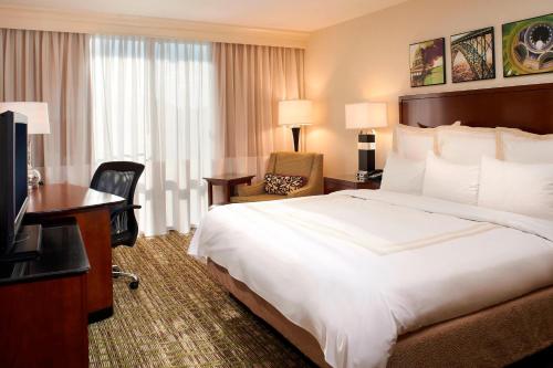 a hotel room with a bed and a television at Charleston Marriott Town Center in Charleston