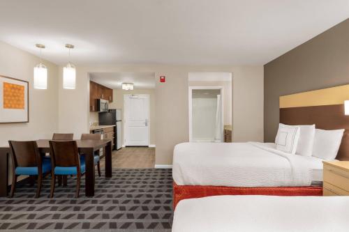 TownePlace Suites by Marriott Chattanooga Near Hamilton Place في تشاتانوغا: غرفة في الفندق مع سرير وغرفة طعام