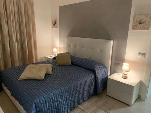 1 dormitorio con 1 cama azul y 2 lámparas en leupupe relax cultura mare monti, en Cascina