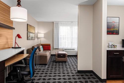 a hotel room with a desk and a couch at TownePlace Suites by Marriott Dallas Plano/Legacy in Plano