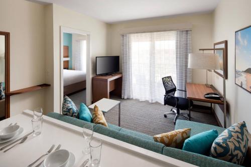 a hotel room with a blue couch and a bedroom at Residence Inn by Marriott Maui Wailea in Wailea