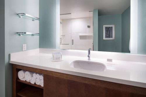 a bathroom with a sink and a mirror and towels at Residence Inn by Marriott Maui Wailea in Wailea