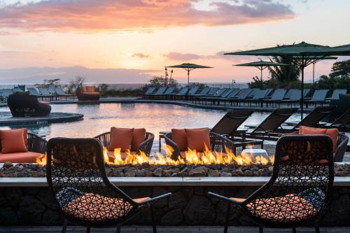 a fire pit at a resort with chairs and a pool at Residence Inn by Marriott Maui Wailea in Wailea