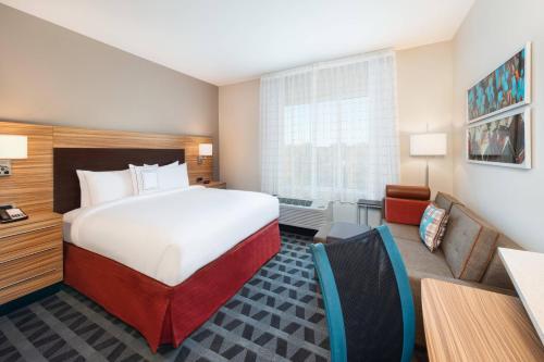 ein Hotelzimmer mit einem Bett und einem Wohnzimmer in der Unterkunft TownePlace Suites Atlanta Lawrenceville in Lawrenceville