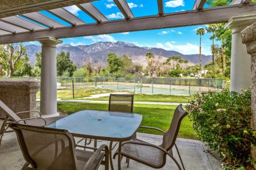 a patio with a table and chairs and a tennis court at Mesquite Condo in the Sun in Palm Springs